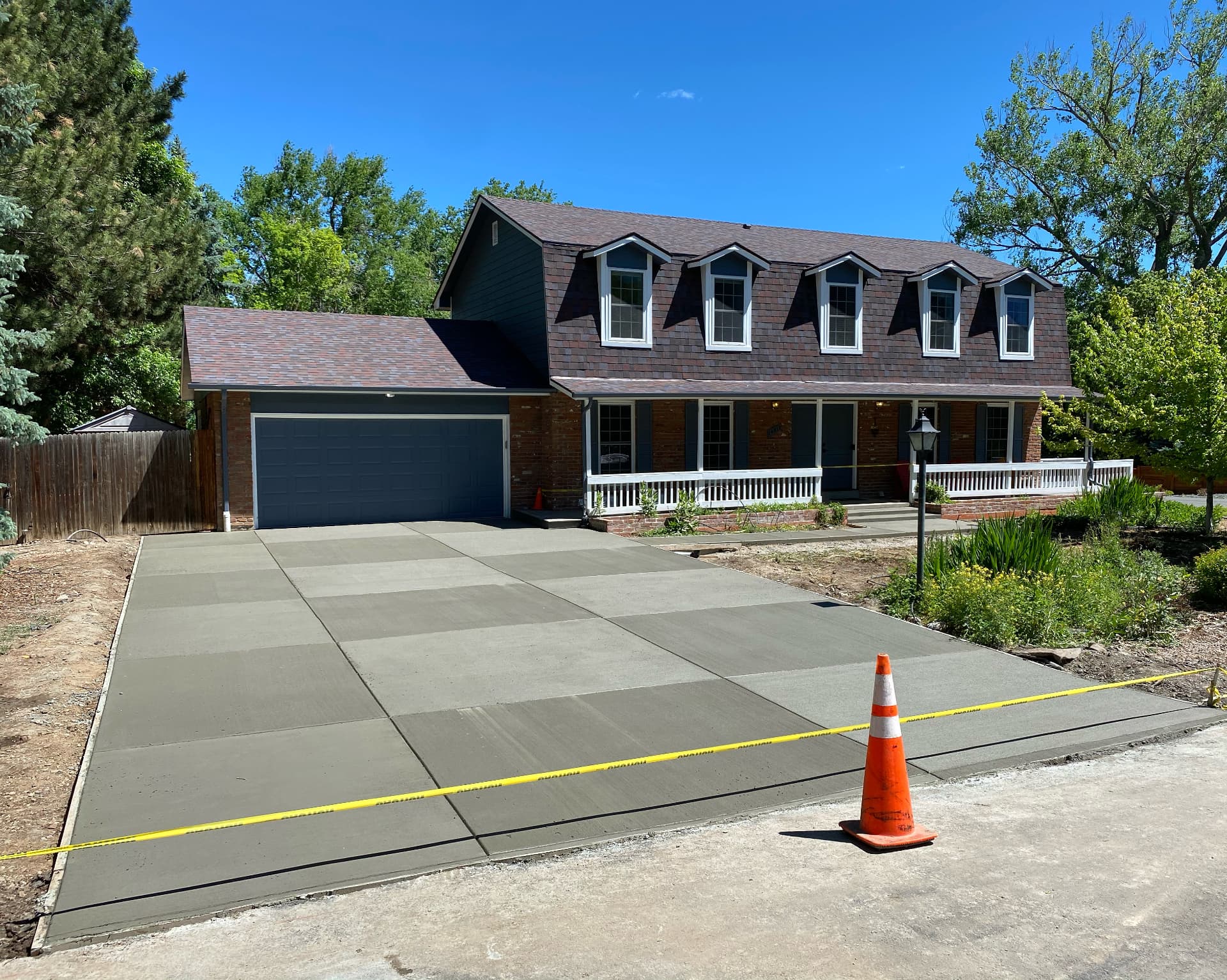 Newly replaced concrete driveway in front of a two-story home