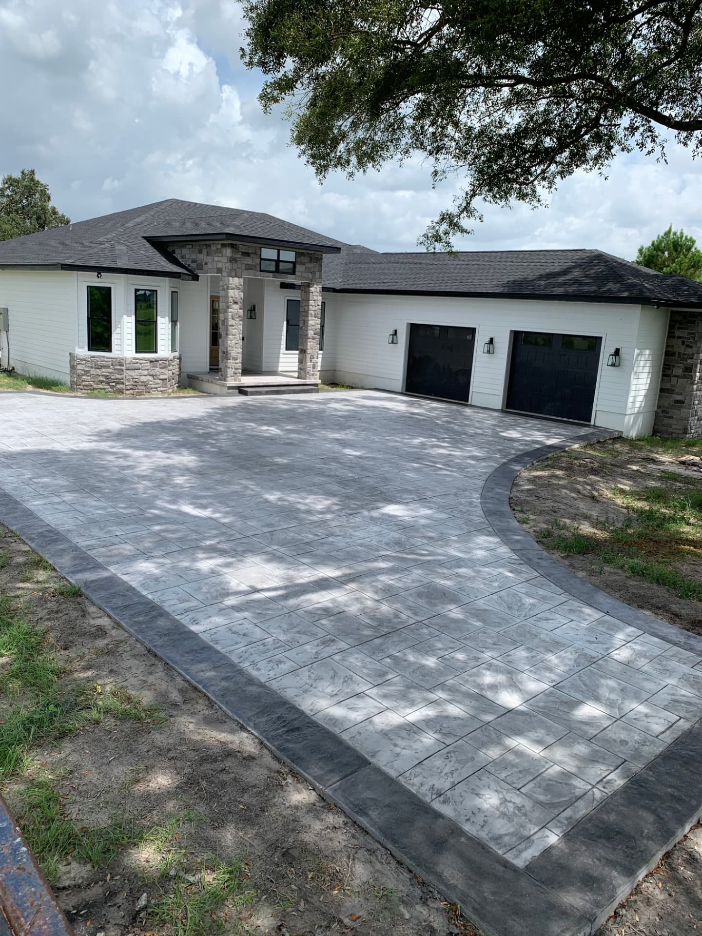 Ashlar-slate stamped concrete drive court with a charcoal border in North Central Florida