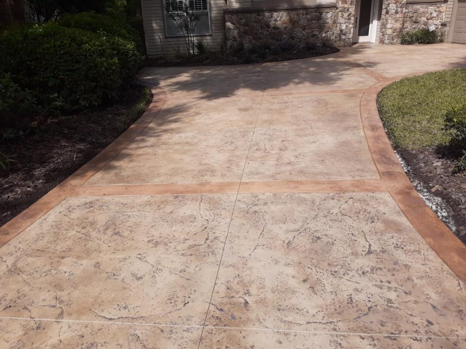 Stained and stamped concrete driveway with darker border in Marion County, Florida