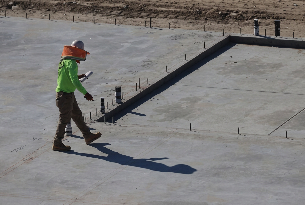 Finished concrete slab with plumbing sleeves being inspected in Newberry, Florida
