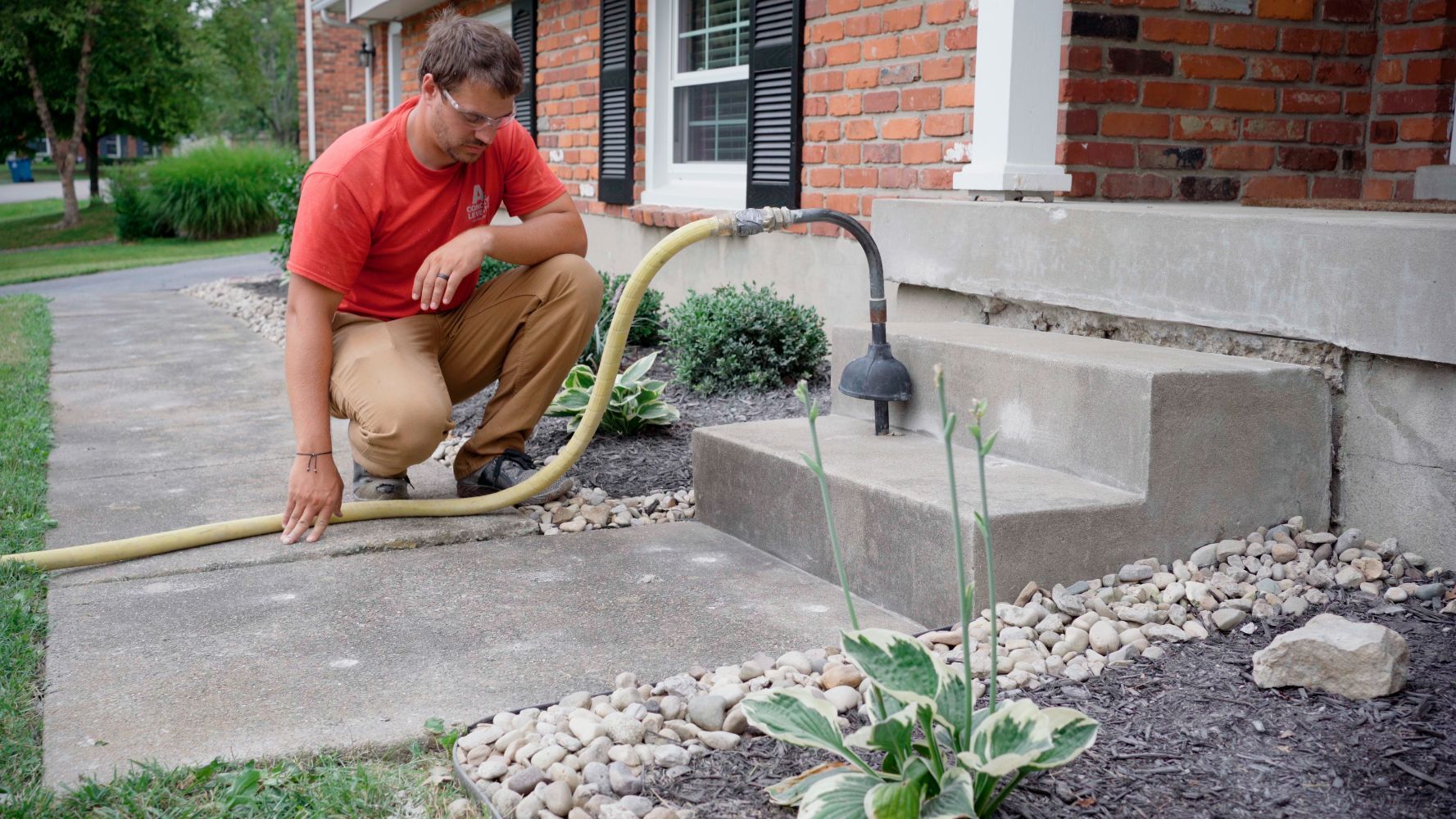 Technician leveling settled concrete steps and walkway in Bronson, Florida