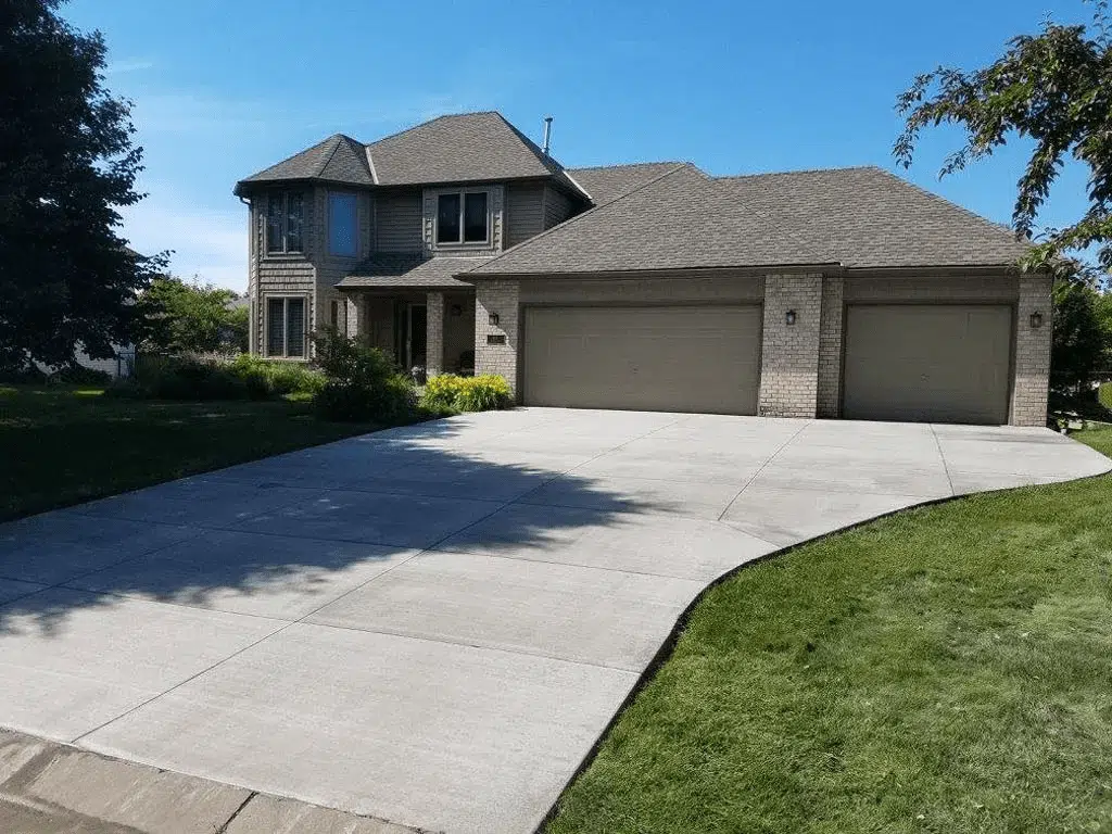 Wide concrete driveway with curved apron at a two-story home in Marion County, Florida