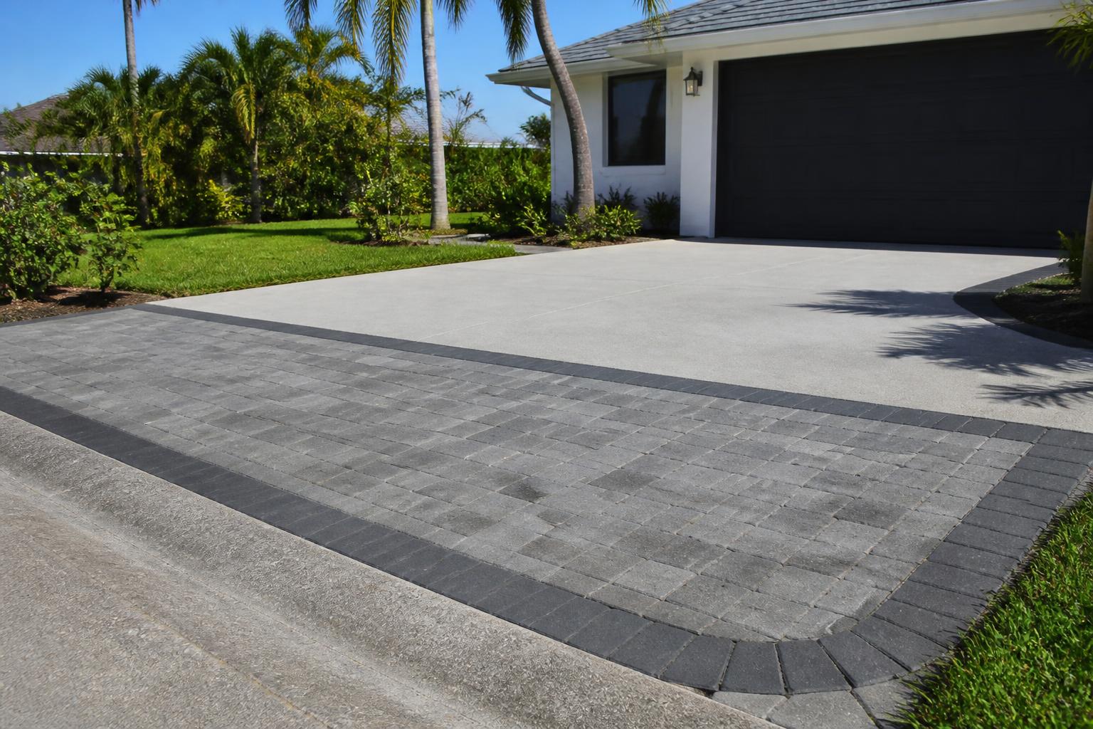 Paver driveway apron with charcoal border meeting a concrete driveway in Trenton, Florida